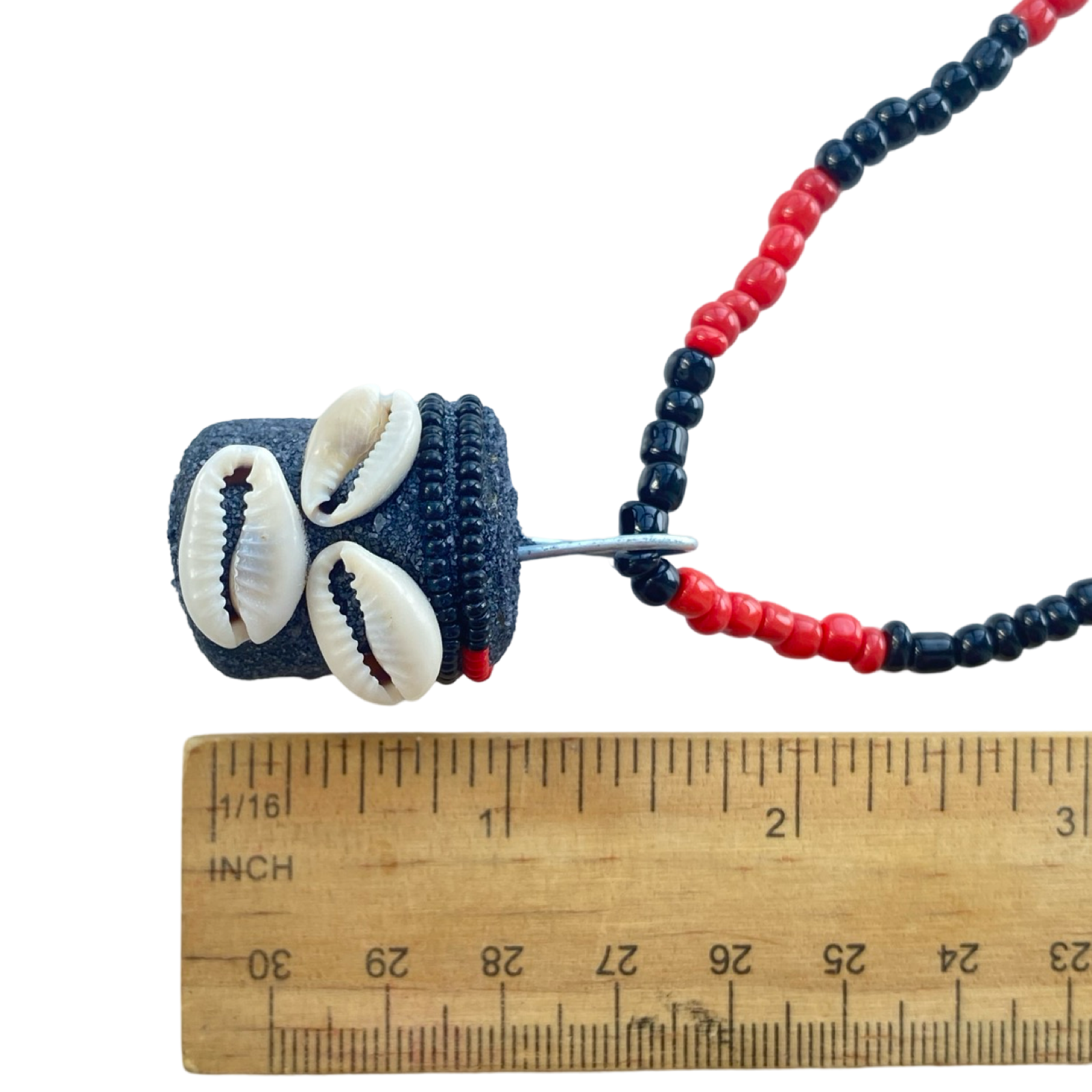 Close-up of the Eleke showing Eleguá’s head pendant and red-black beadwork.