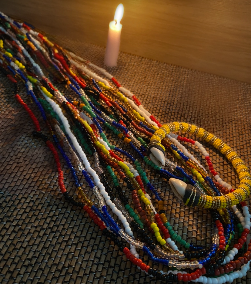 close up of elekes and an ilde laid out on texured cloth with a candle