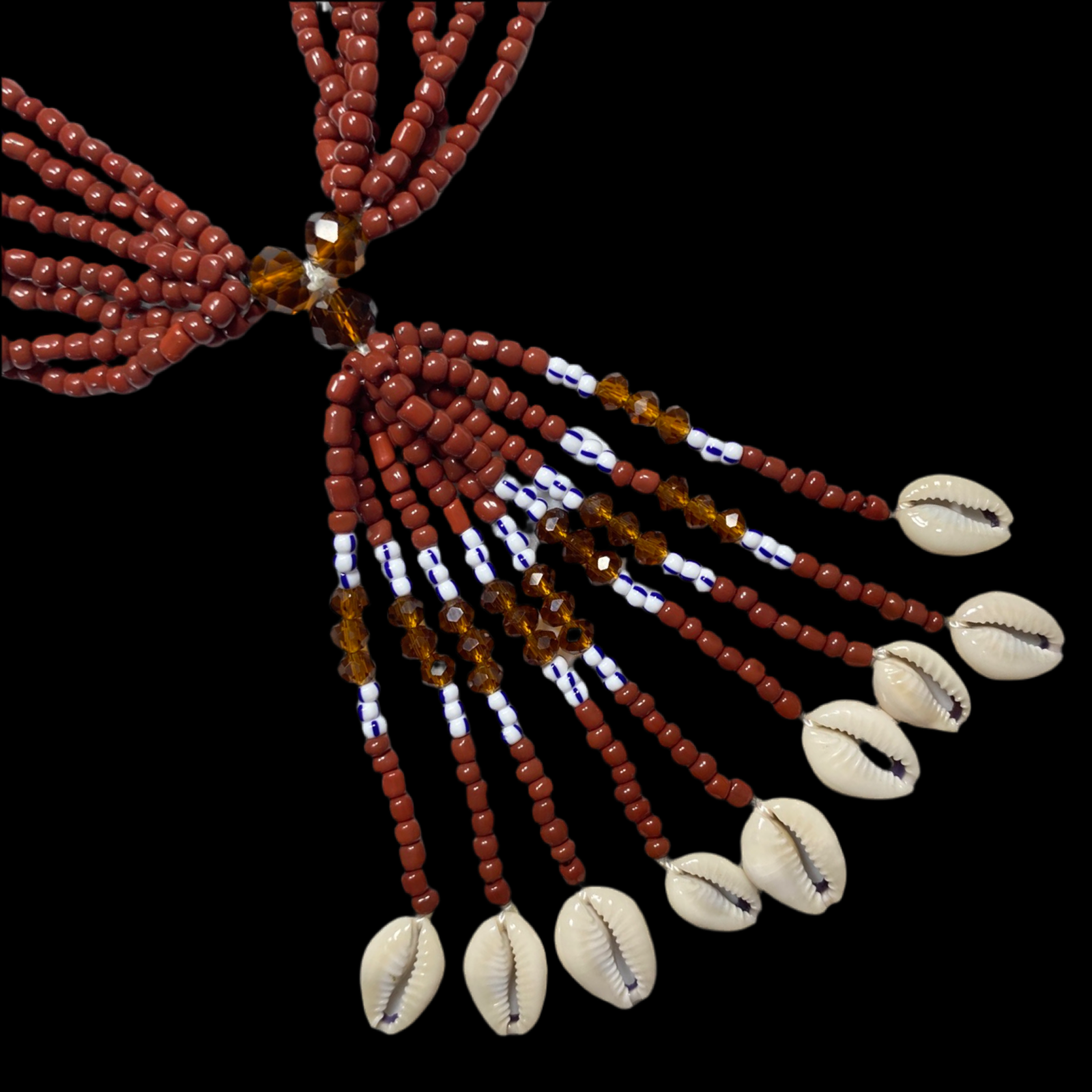 A crystal mazo de babalü ayé with brown and white beads, and cowrie shell decorations, used for ritual purposes in Santería.