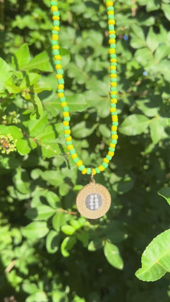 Side view of the pendant representing Orula's sacred divination tray.